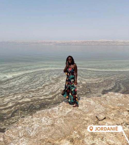 Ina De Becker aan de telefoon bij het water in Jordanië