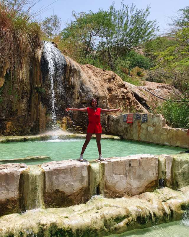 Ina geniet volop van haar vakantie met een prachtige waterval op de achtergrond